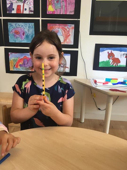 Student showing Chanukah candle at the ELC