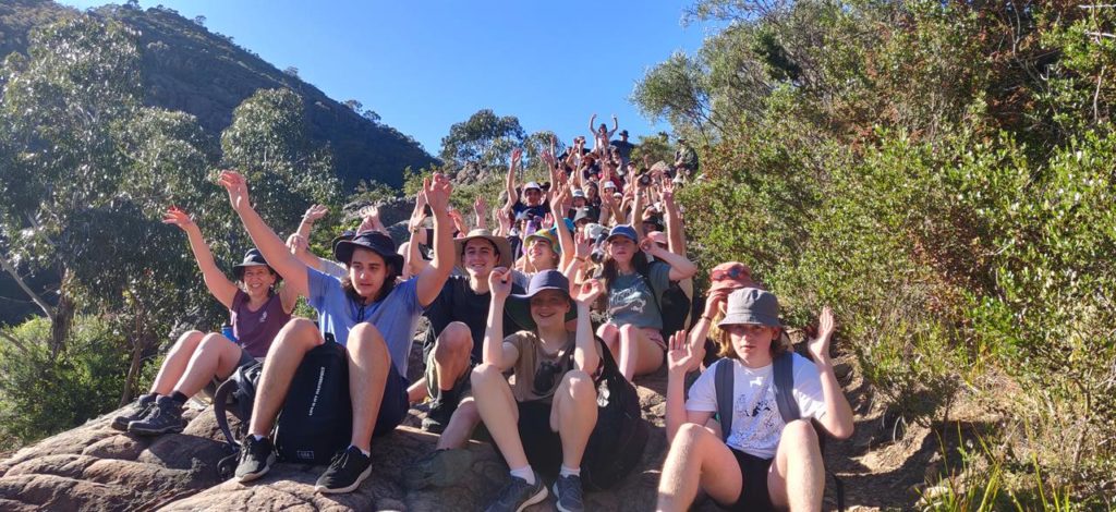 Year 10 students on camp with their hands in the air