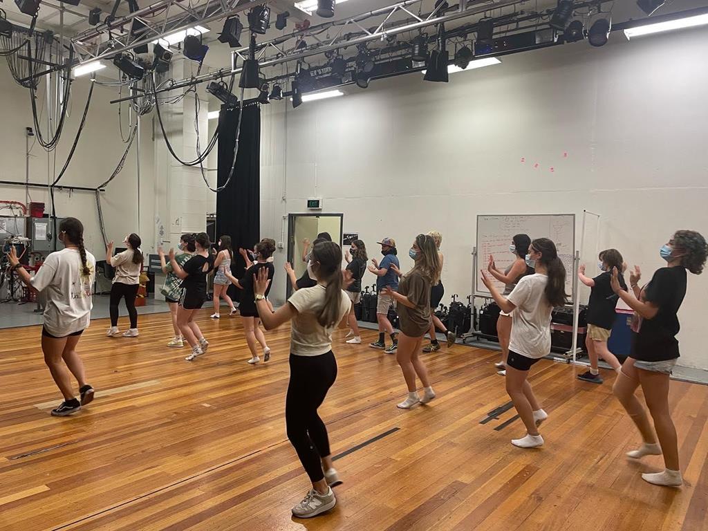 Students dancing at Shir Performing arts camp, on a wooden floor, under lights