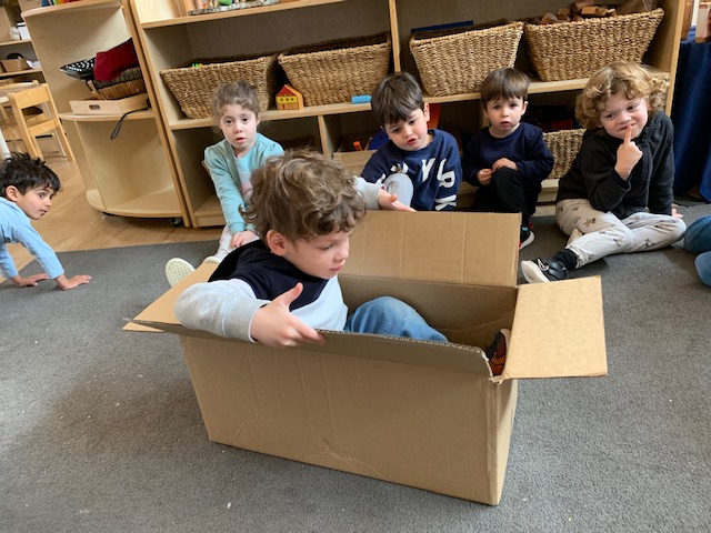 A early learner is in a box, learning about how imagination can help sustainability
