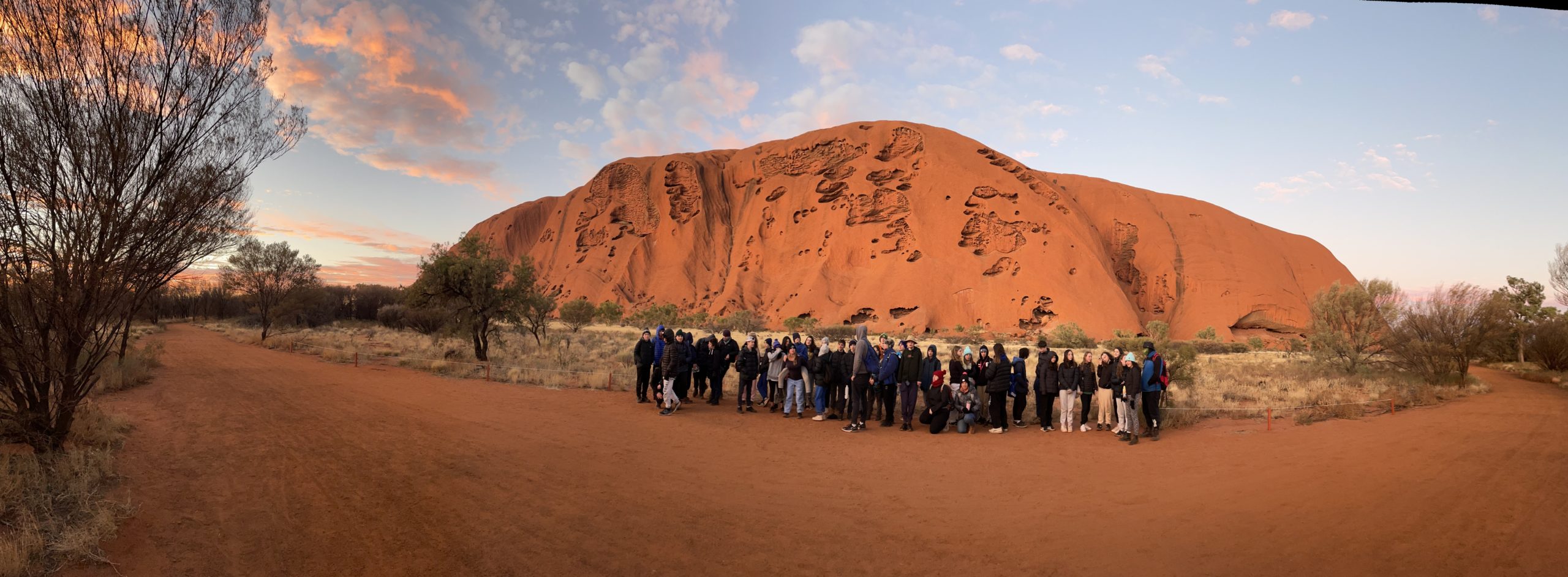 A group of Year 8 students are in front of Uluru in Central Australia