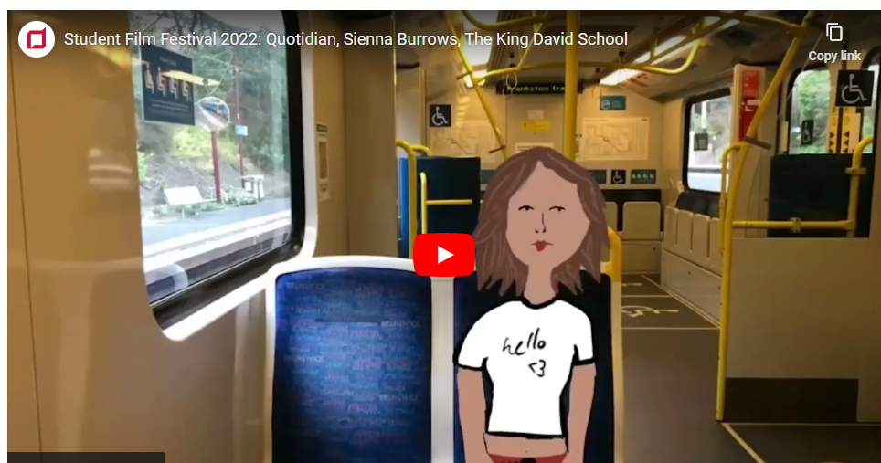 The image is a still from a student's film that won highly commended in the Independent Schools Victoria Film Competition. It shows a girl sitting on a bus, wearing a vintage-style white t-shirt.