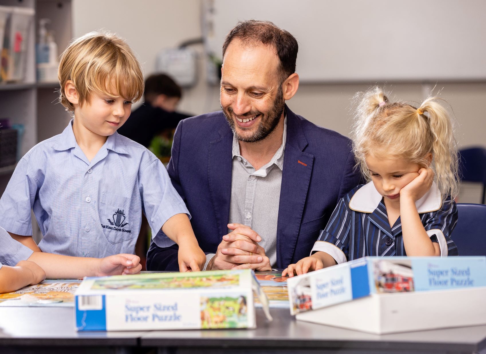 Principal Marc Light is with two Prep students. They are facing the camera and looking down at a game they are playing. They are at their first day of school - building a love of learning and strong Jewish identity.
