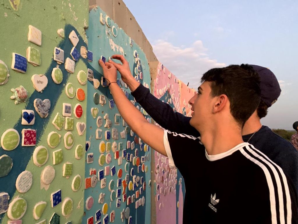 Students are on the Gaza strip decorating the Wall for Peace