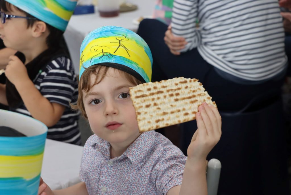A student in our ELC holds a piece of Matzah - he is celebrating Pesach.