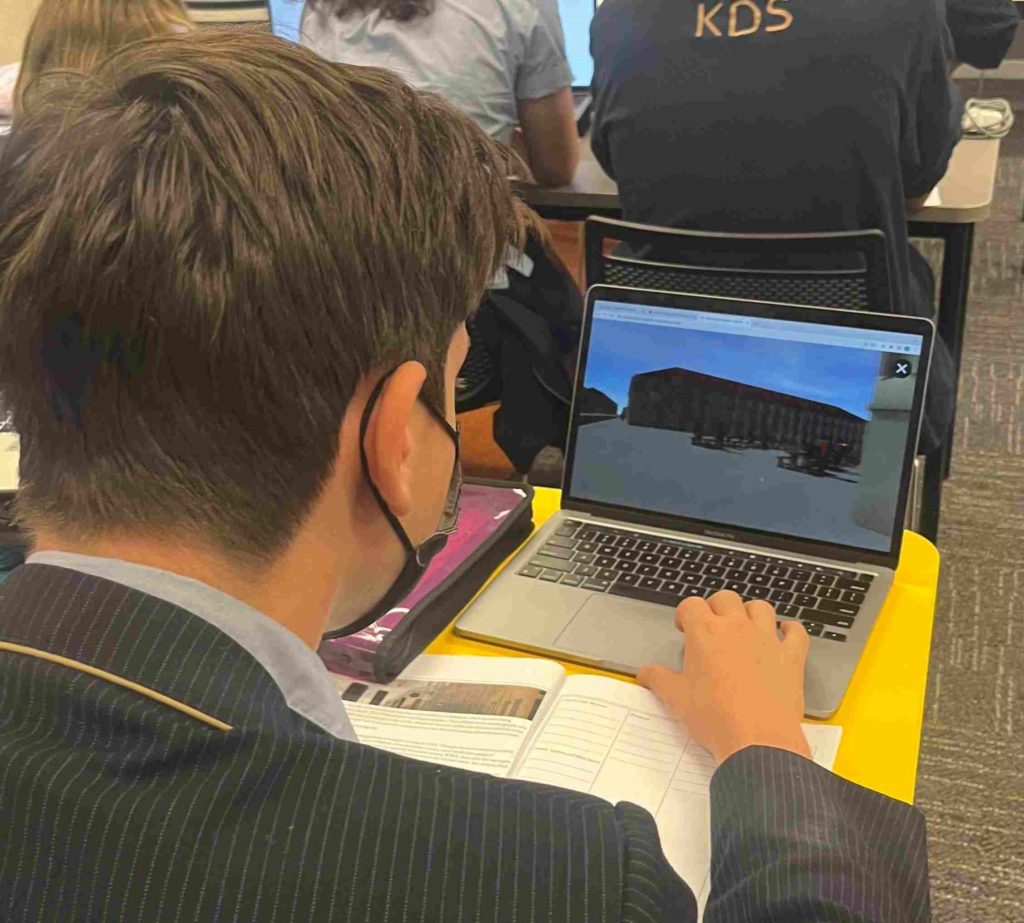 A student is looking at their laptop, where they are exploring a virtual tour of the Vilna Ghetto in the 19th century.