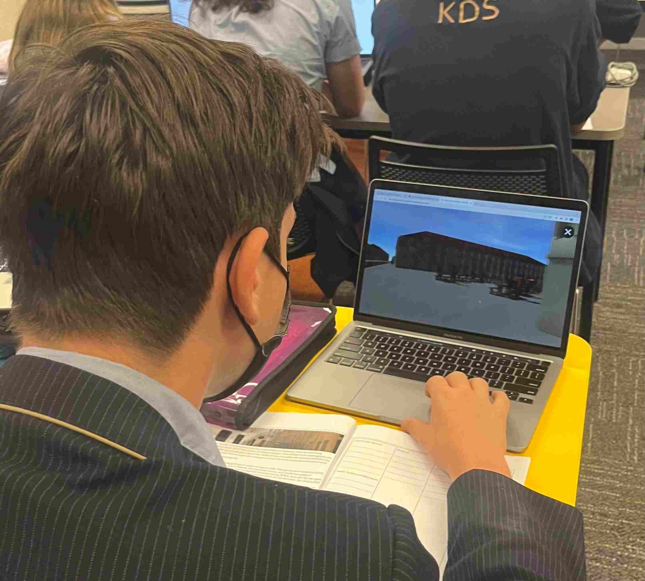 A student is looking at their laptop, where they are exploring a virtual tour of the Vilna Ghetto in the 19th century.