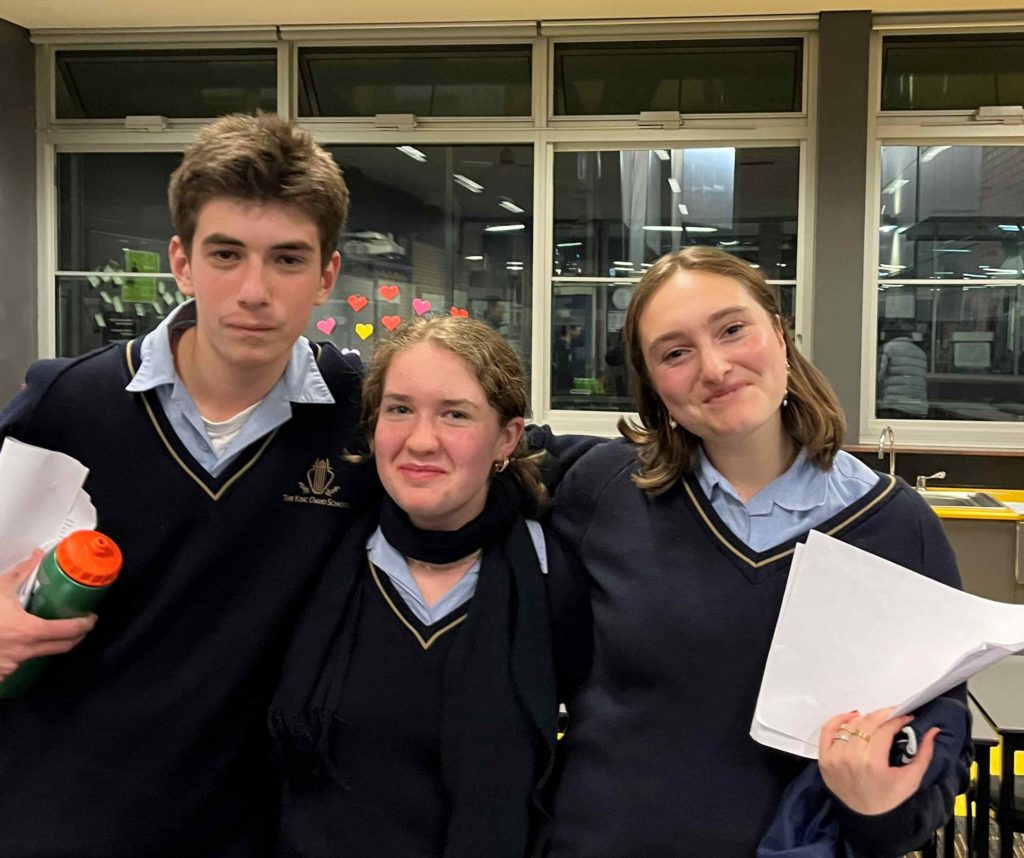 Three students smile at the camera - they have just won debating against rival school Mt Scopus