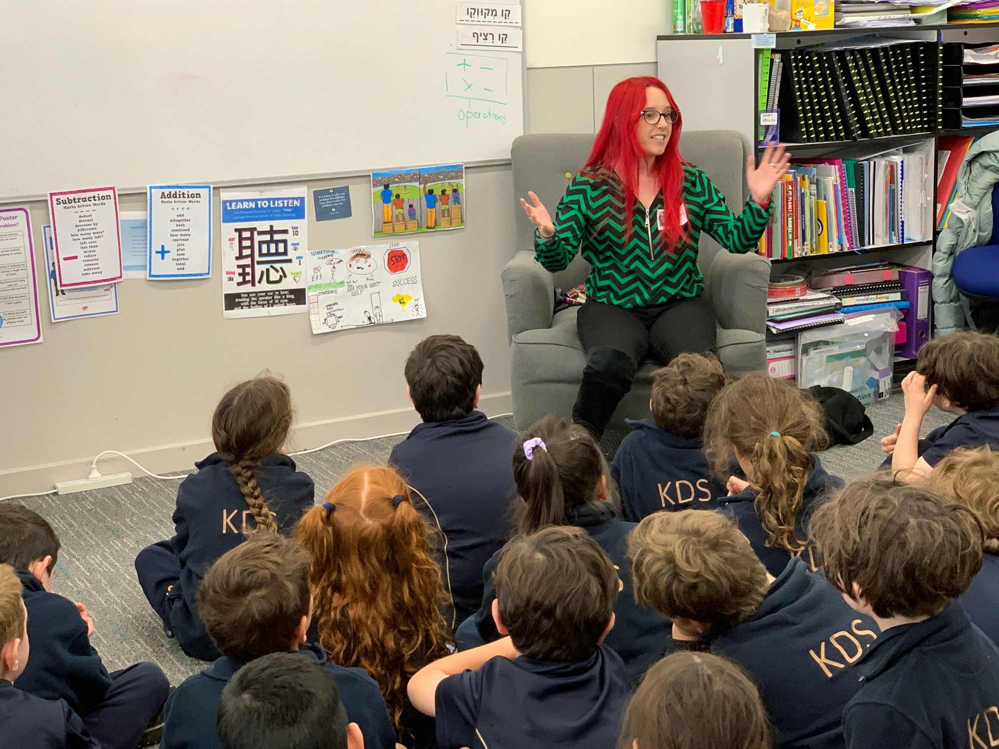 Dr Sebben has bright red hair. She is at the front of the class waiving her hands as she excitedly talks water science to our Year 2 students