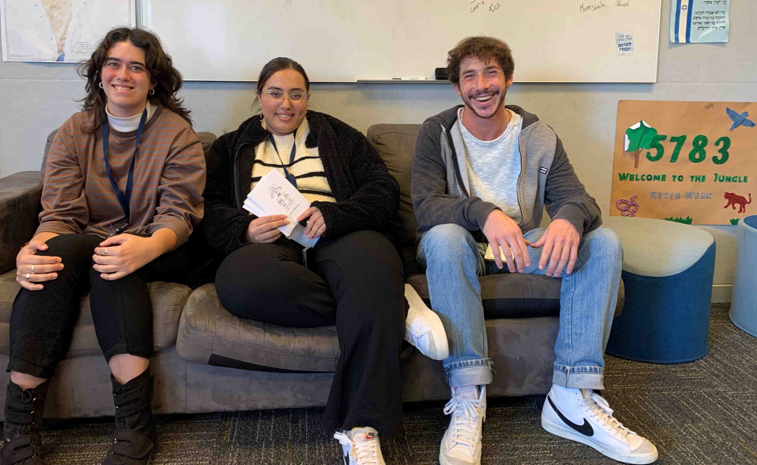 Our three Israeli Madrichim (guides) are sitting on a couch together. They are looking at the camera and smiling.