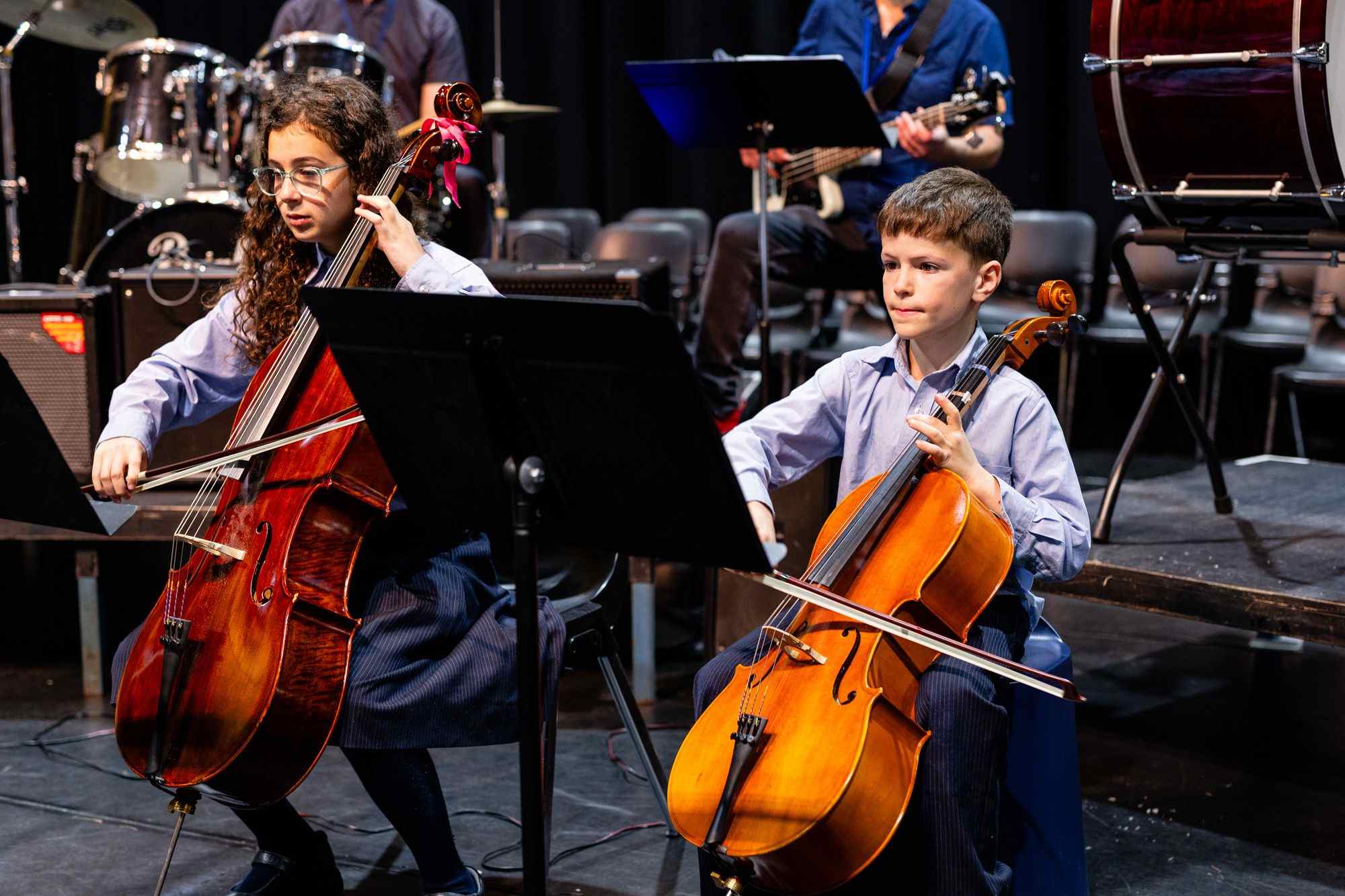 Two students play the cello at our annual Spring concert. They are concentrating.