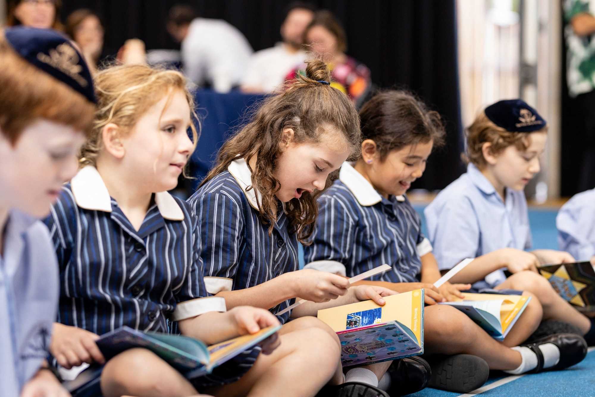 Year 3 students receive their Siddur at a special ceremony. They are wearing school uniform and singing and looking at their Siddurim