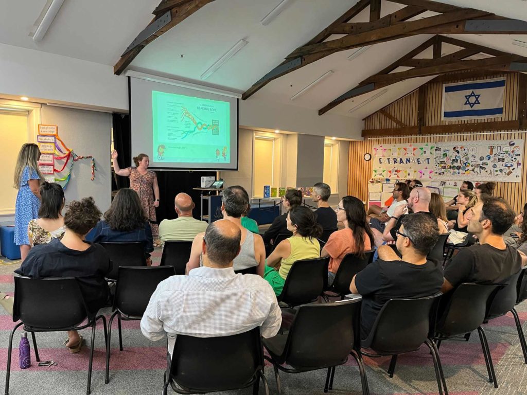 Prep teachers are at the front of the hall, presenting to parents of Prep children about how they can help their children learn how to read.