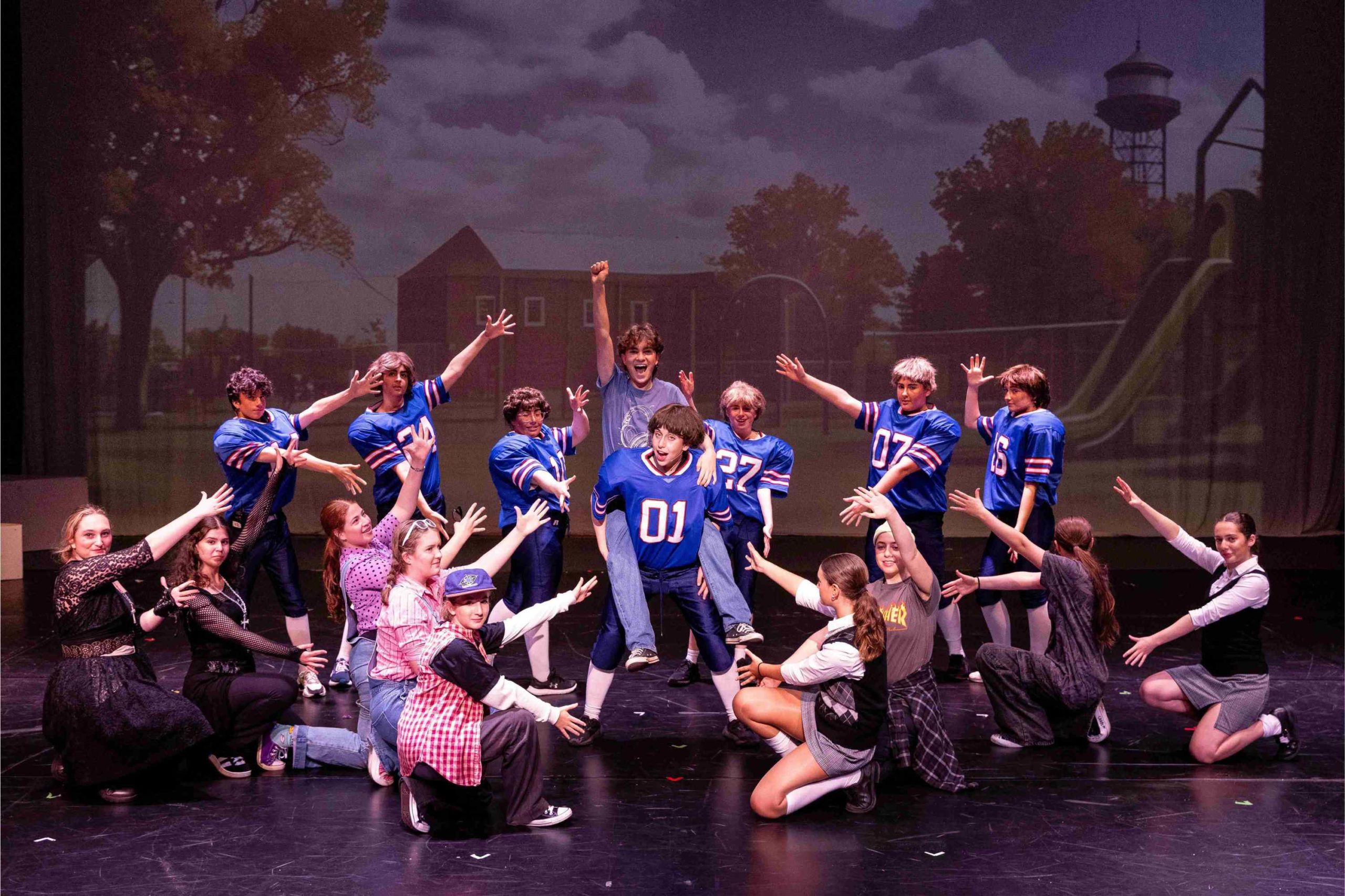 Characters in 13 the musical are in formation around the two lead characters - a jock and a regular boy.