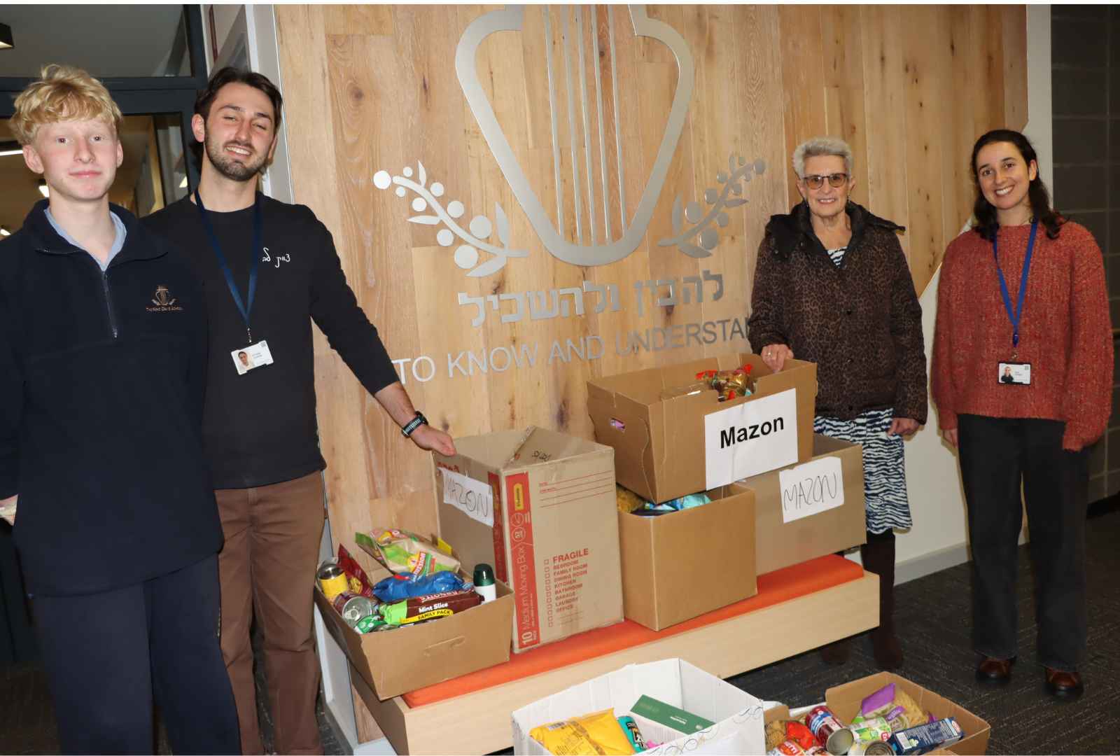 A Year 8 student and two King David staff members stand with Ellen from Mazon Australia with boxes of food they are donating to help feed the hungry.