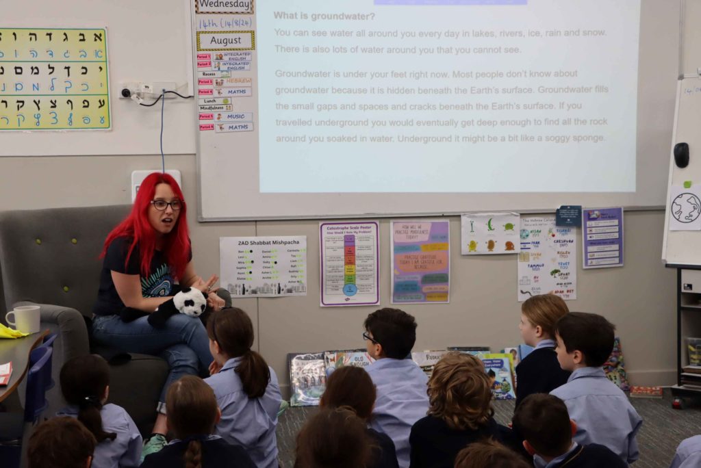 Dr Megan is sitting with Year 2 students teaching them about the importance of groundwater in Australia