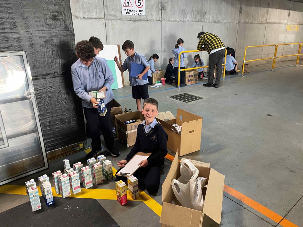 The Year 5 Tzedakah charity vaadah with food items they have collected for Food Bank Victoria