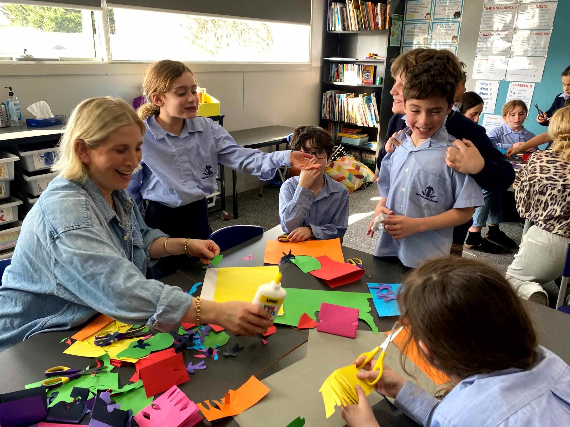 Students are cutting colourful pieces of paper representing family for Yom HaMishpachah - Family Day.