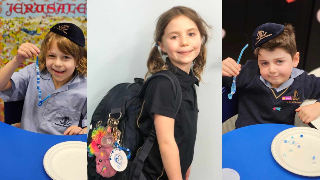 Three Junior School students are shown with the bag tags they made to commemorate Oct 7.