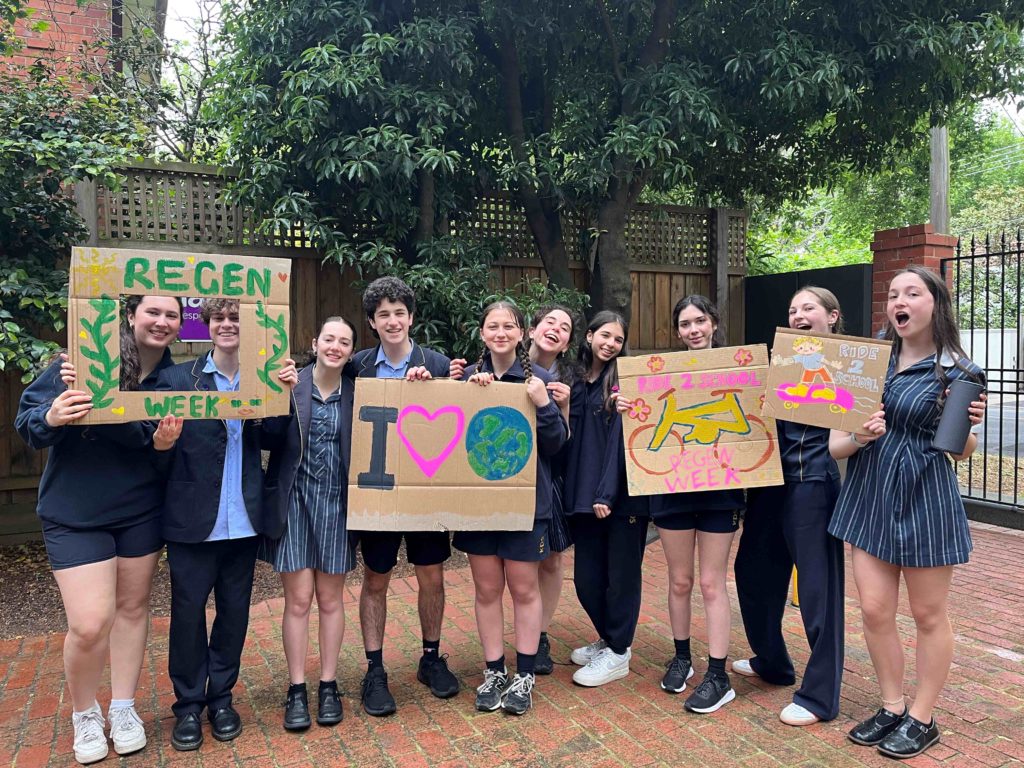 Student leaders pose with signs for regeneration week at KDS.