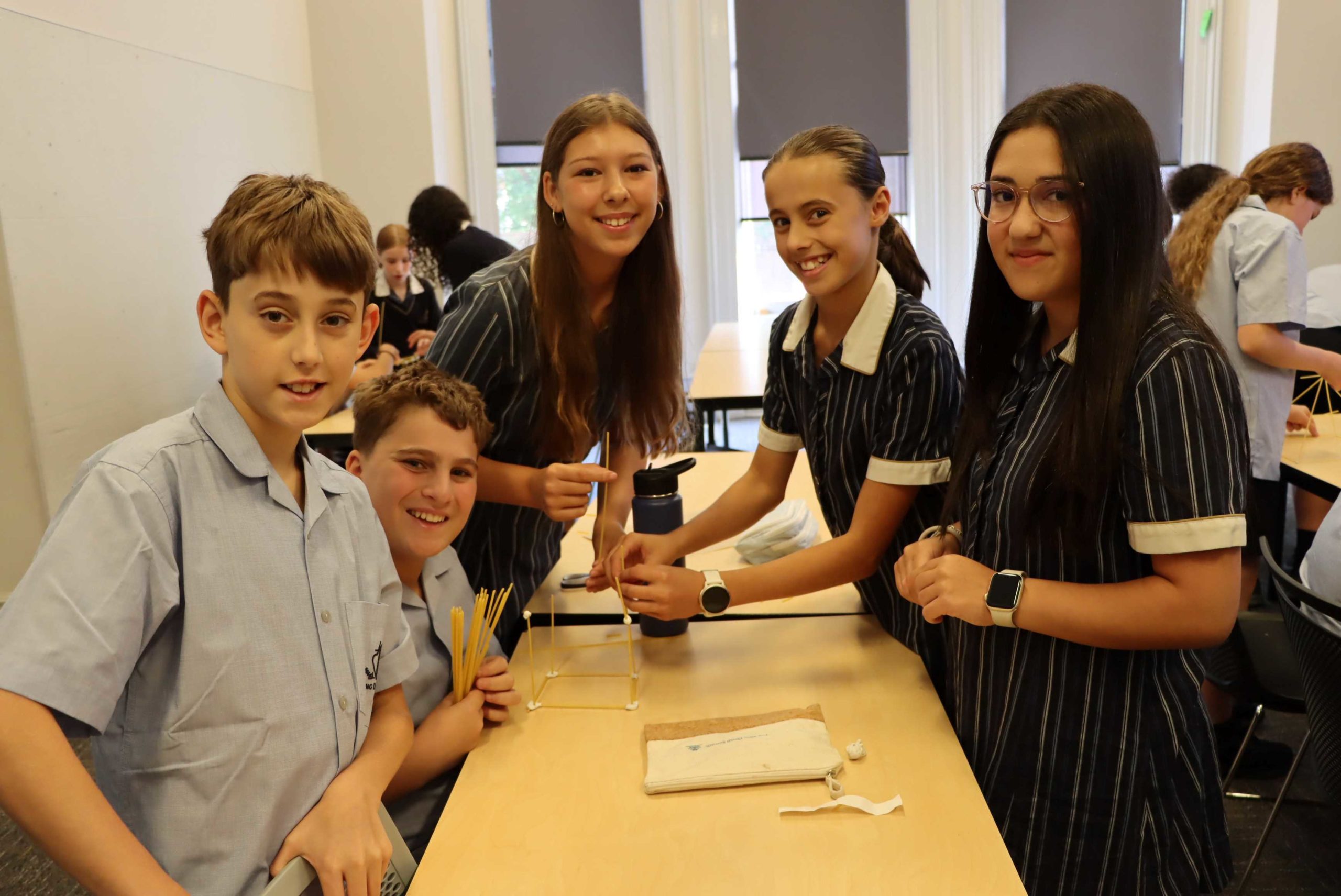 Year 7 students are participating in the Young Scientist program as part of Launch Experience. They are building a high tower. They are smiling.
