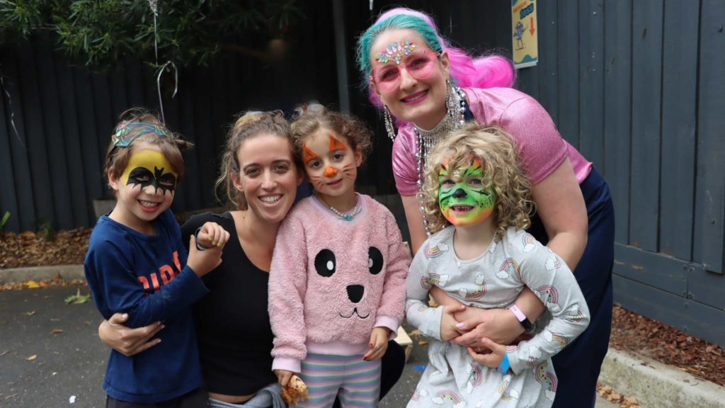 Adulats and children have their faces painted and are in disco costumes as they celebrate Purim early with a family fun disco