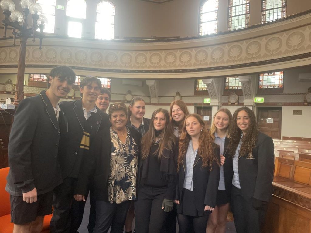 Students are at St Kilda Shule. They are wearing academic school uniform. They are meeting Rachel Edri, who used her wit to survive October 7.