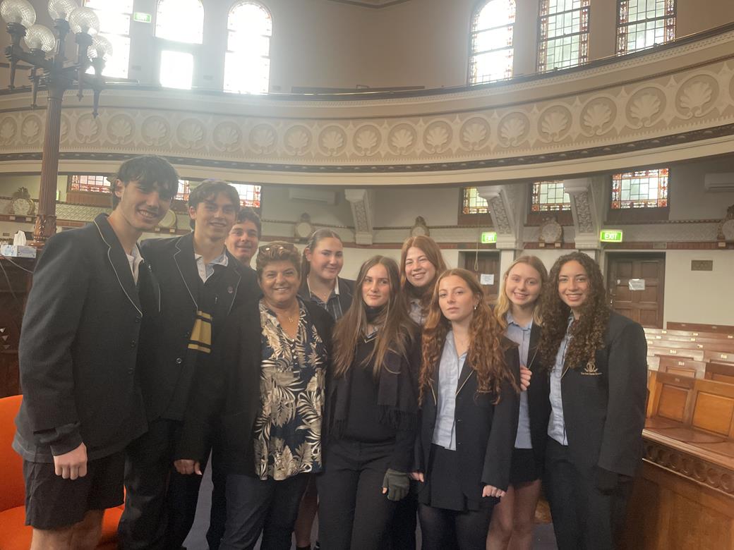 Students are at St Kilda Shule. They are wearing academic school uniform. They are meeting Rachel Edri, who used her wit to survive October 7.