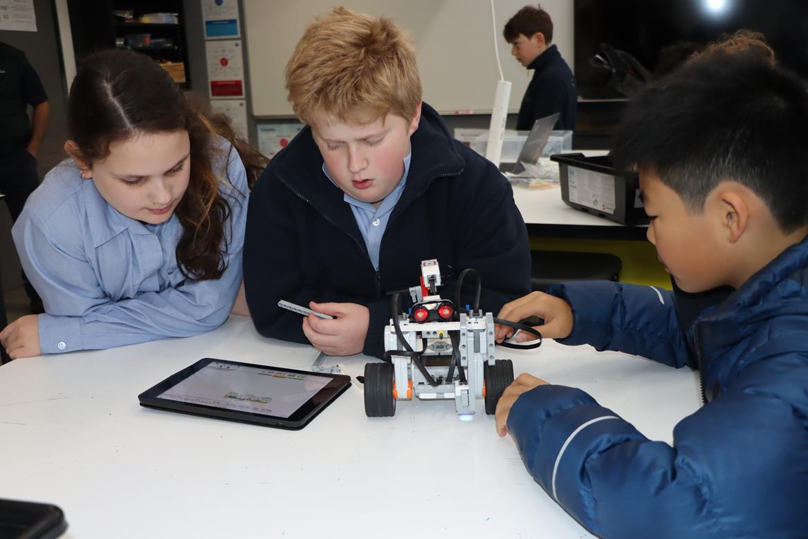 Year 6 students work together to program a robot.