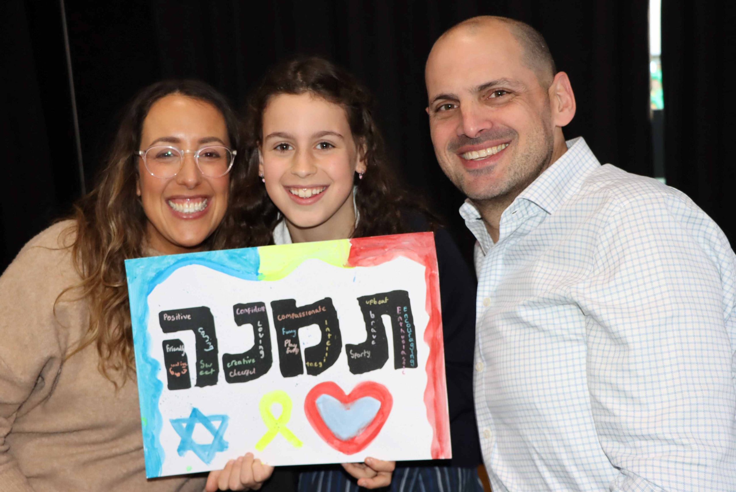 Two parents smile with their Year 4 child -they are celebrating our Hebrew names.