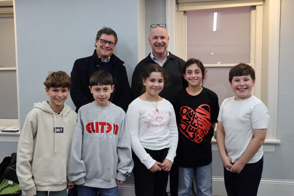 Year 5 students are smiling with the Head of Junior School and with a celebrated author. They have just written a book in a day.