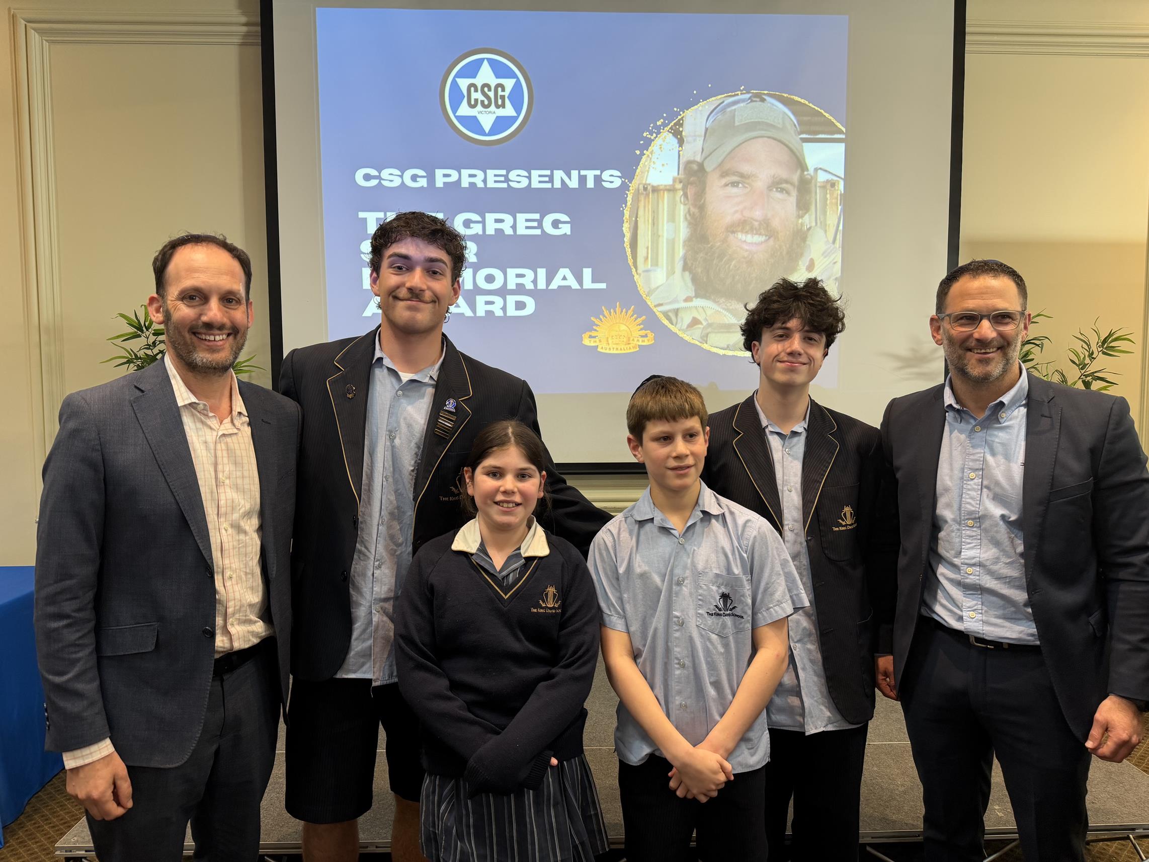 The recipients of the CSG Greg Sher award pose with the CEO of CSG. They are happy to be recognised for their services to community.
