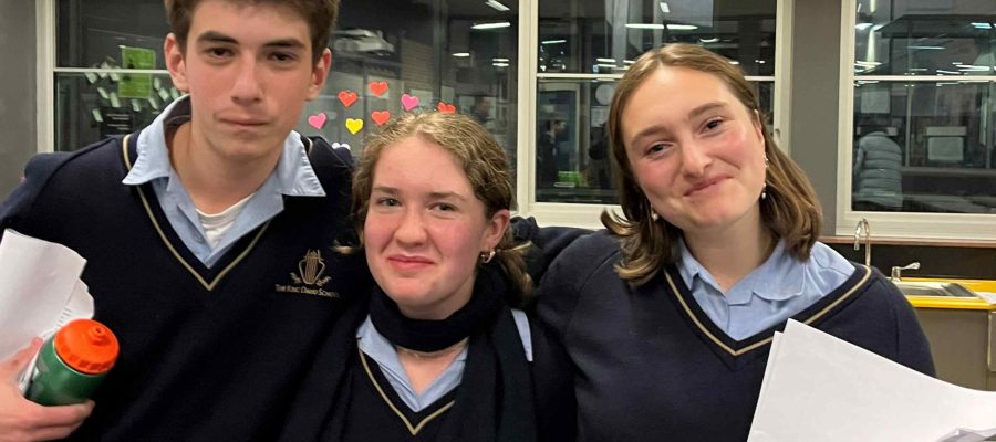 Three students smile at the camera - they have just won debating against rival school Mt Scopus