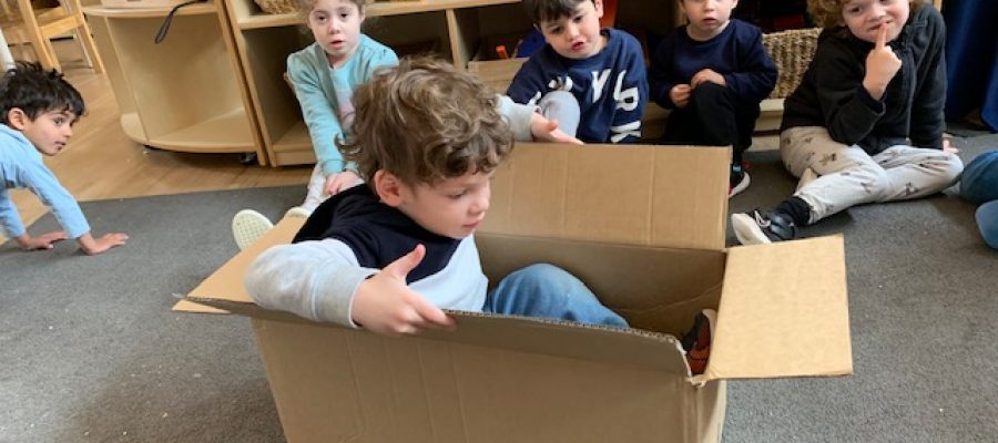 A early learner is in a box, learning about how imagination can help sustainability